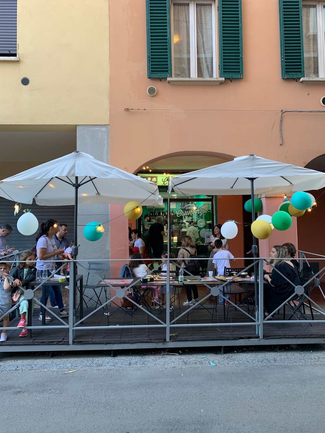 Esterno di Crunchy con tavoli, ombrelloni e palloncini per un piccolo rinfresco